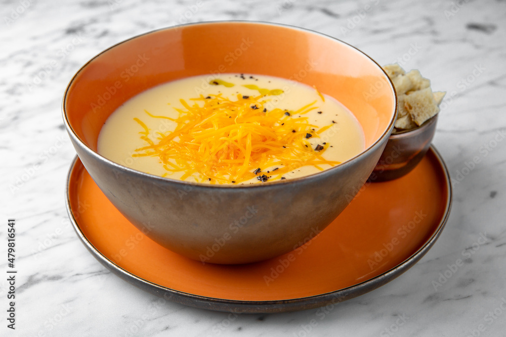 Cream cheese soup. First course in a festive plate on a marble background. Restaurant banquet menu. Cream cheese soup. First course in a festive plate on a marble background. Restaurant banquet menu.