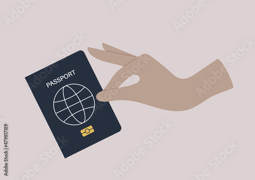 A hand holding a passport cover, a citizenship ID document