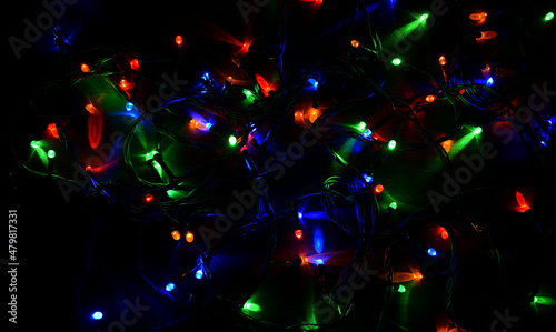 Electric garland on a wooden background, bright bulbs, night