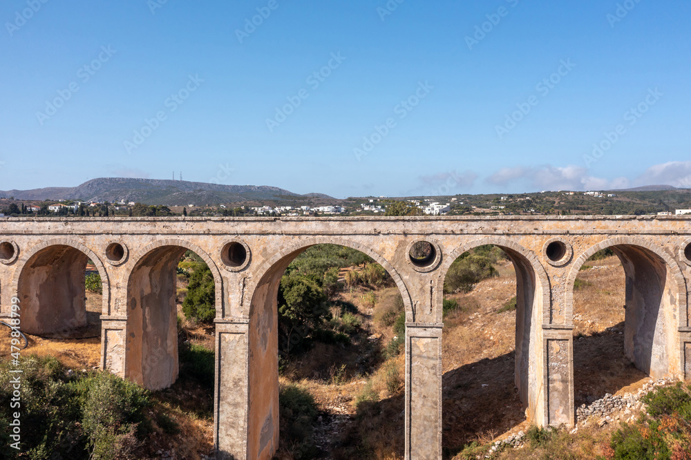 The stone bridge of Katouni in Kythira Greece with arches and round openings, sunny day.