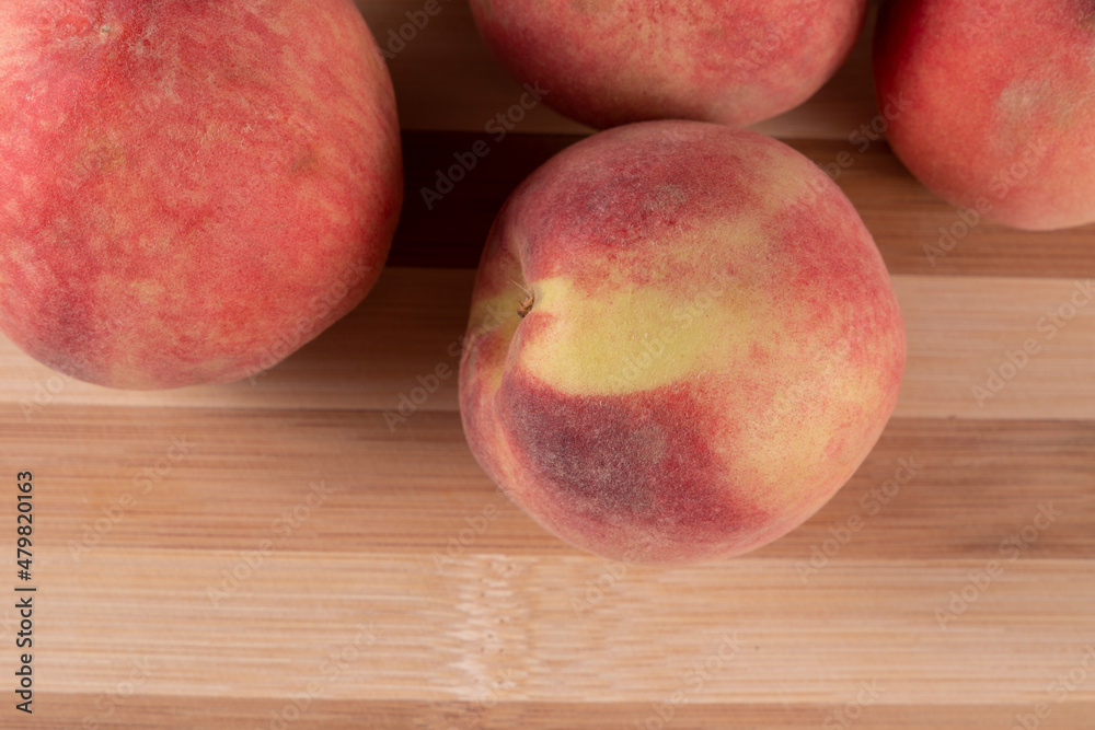 Tasty peaches (Prunus persica, in Latin), on wooden board, on rustic wooden table. Selective focus. Top view. Tasty peaches (Prunus persica, in Latin), on wooden board, on rustic wooden table. Selective focus. Top view.
