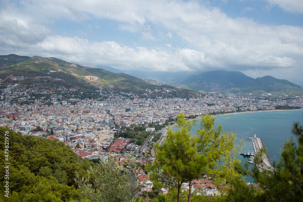 Sea in Turkey, Alanya through trees. Lighthouse in the background. View from above.