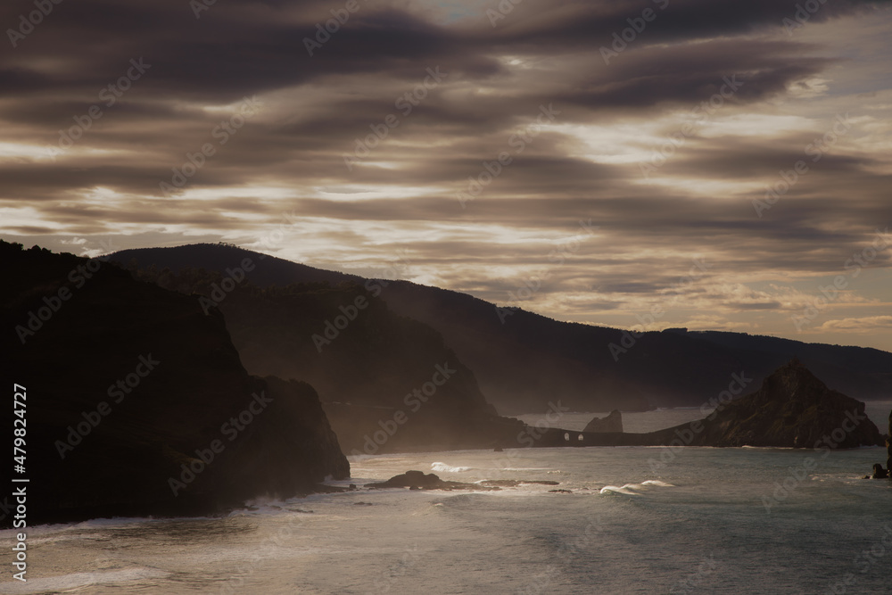 landscape of cliffs at sunset with hermitage of Gaztelugatxe in the background