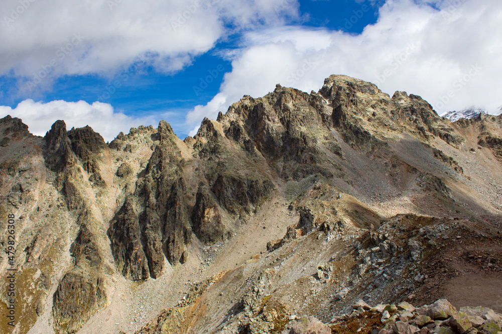 Mountain view from cliff at very high altitude. Scenic alpine landscape with beautiful sharp rocks in sunlight. Beautiful scenery with sharp stones.