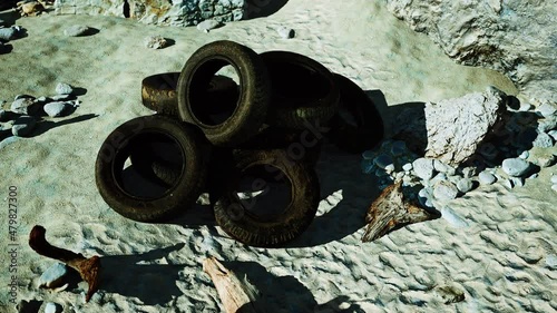 old tires overgrown embedded in the sand