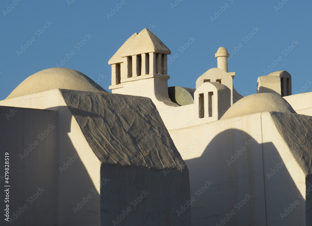 Beautiful roof with many white traditional diferent chimneys. Architecture in the South of Tenerife Island. Canary Islands. Spain.