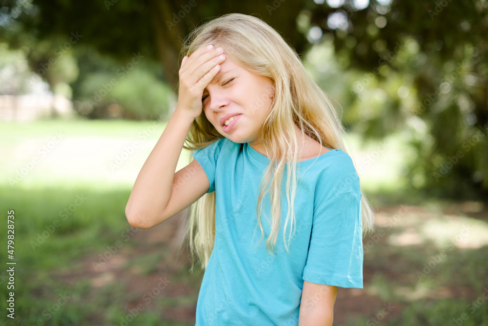 A very upset and lonely Caucasian little kid girl wearing blue T-shirt standing outdoors crying,