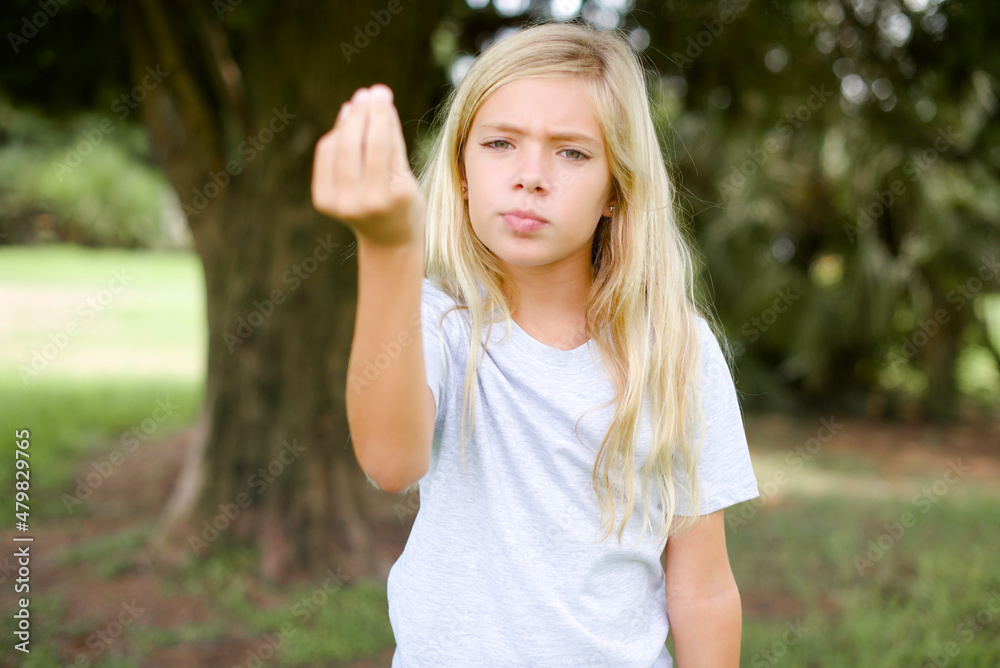 Caucasian little kid girl wearing whiteT-shirt standing outdoors Doing Italian gesture with hand and fingers confident expression Caucasian little kid girl wearing whiteT-shirt standing outdoors Doing Italian gesture with hand and fingers confident expression