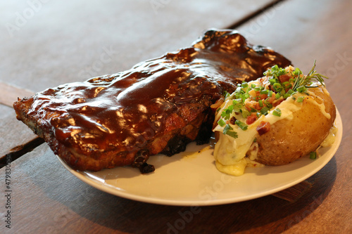 Pork Ribs and Barbecue Sauce with Baked Potatoes Stuffed with Cheese, Bacon and Spices