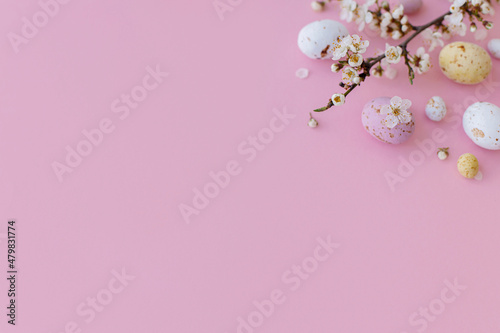 Easter flat lay with space for text. Colorful Easter chocolate eggs and cherry blossoms border on pink background. Happy Easter!. Stylish tender spring banner template. Greeting card © sonyachny
