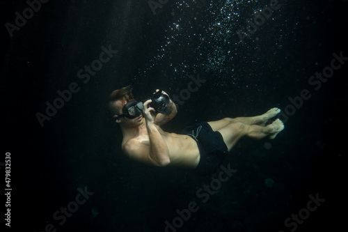 young man taking underwater pictures doing free dive