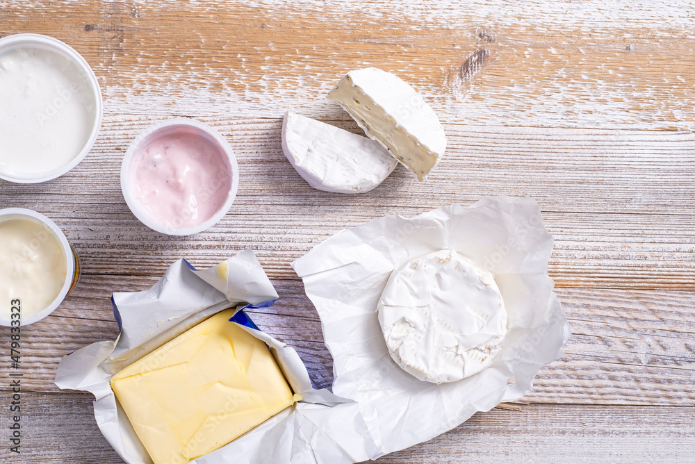Yoghurt and cheeses on a wooden table. - obrazy, fototapety, plakaty 