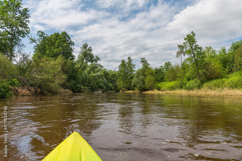 Fototapeta Naklejka Na Ścianę i Meble -  Bow of the yellow kayak on a calm river. Summer outdoor activity