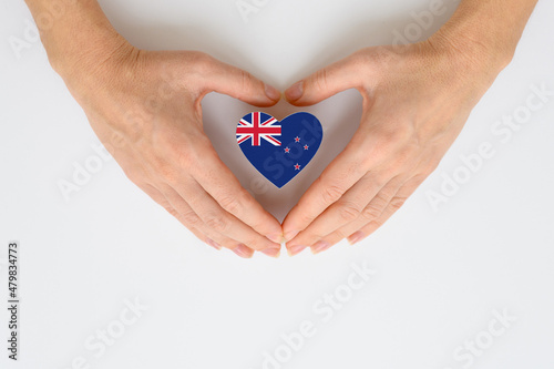 The national flag of New Zealand in female hands.