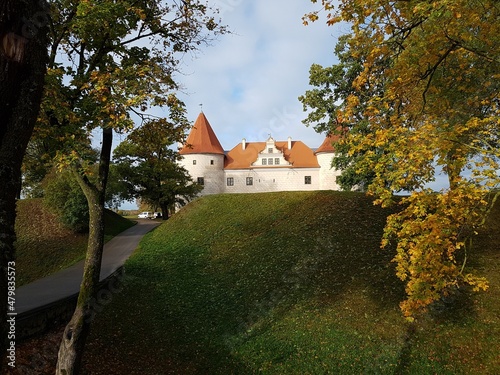 Old Latvian castle in the town of Bauska among trees with yellowed leaves October 16, 2020