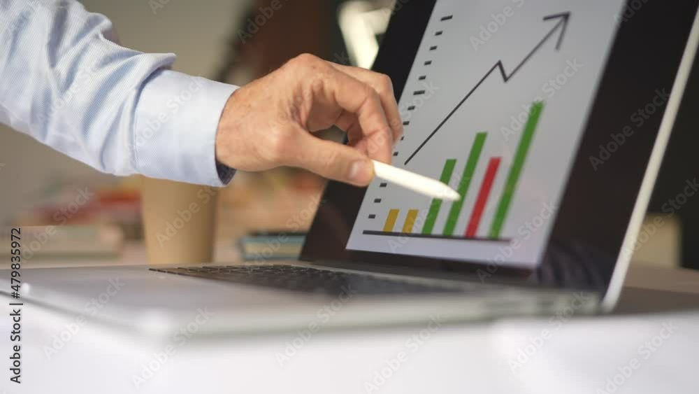 Closeup dolly shot of a businessman hand showing positive financial data on the screen of a tablet laptop to sign success of the company. Closeup dolly shot of a businessman hand showing positive financial data on the screen of a tablet laptop to sign success of the company.