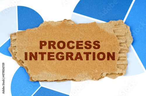 On the blue financial charts is a piece of cardboard that says - Process Integration photo