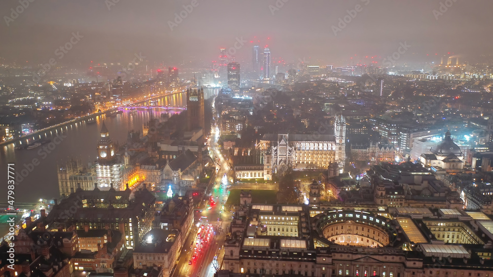 Fototapeta premium Aerial drone night shot of iconic City of Westminster with houses of Parliament, Big Ben in front of river Thames, London, United Kingdom