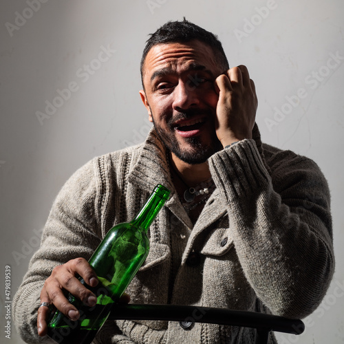 Alcoholic man with bottles wine cry. Depressed crying man. Drunk alcohol addict man drinking whiskey, depressed as alcoholic suffering alcoholism problem and alcohol addiction.
