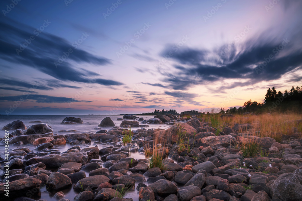 Long Exposure of Magnificent Soft and colorful sunset by the seaside stone. Beautiful cloud movement