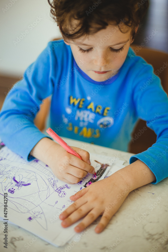 Boy in the blue pajamas writing or drawing something Boy in the blue pajamas writing or drawing something