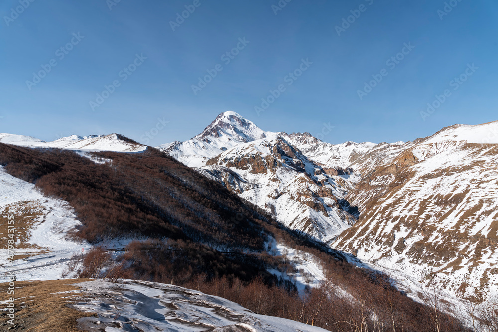 High snow covered mountain Kazbek. Winter mountains landscape. Georgia,  Kazbegi.