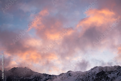 Beautiful winter mountains landscape on the sunrise. High snow covered mountains in the fog.