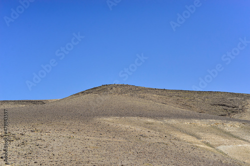 Stone Desert on the West Bank. Judean Desert in clear weather. White sand dunes and blue sky. Stony desert in the spring, green grass. Sand Hills of Judean Mountain, Israel. 