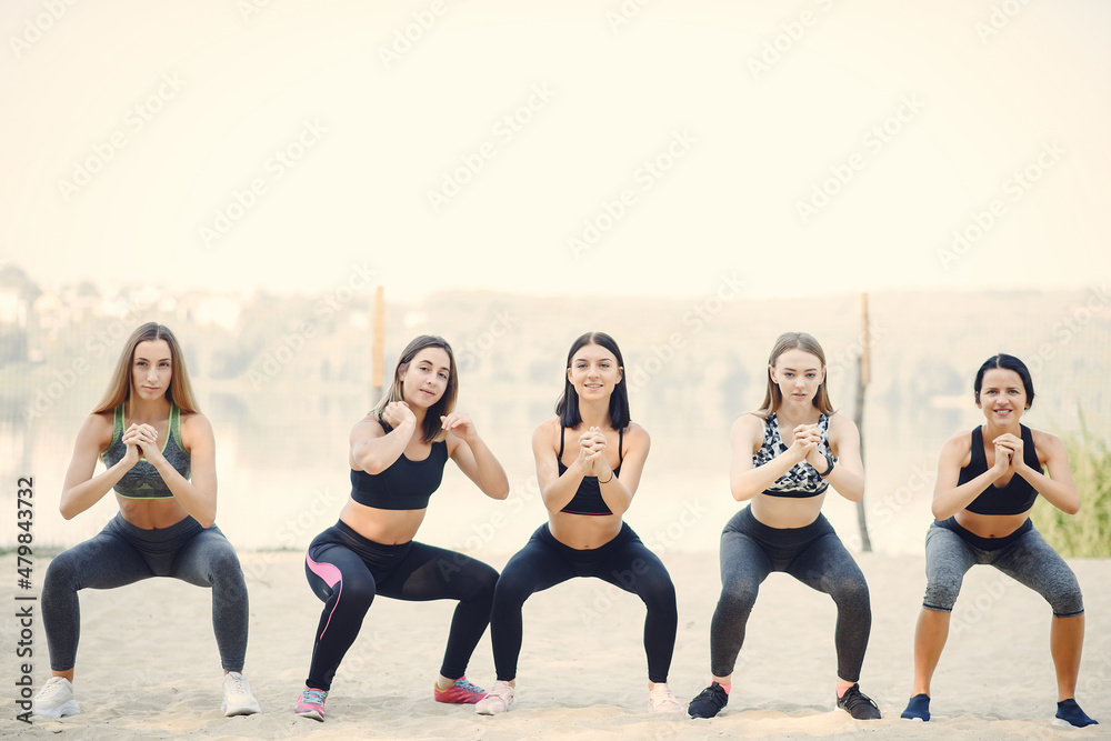 Naklejka premium Sports girls training in a summer park
