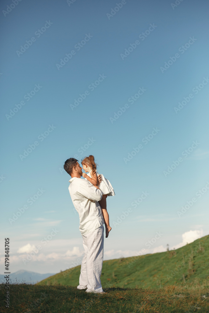 Father playing with ittle daughter in a mountains