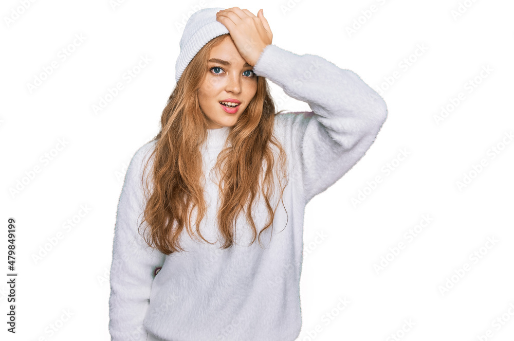 Young caucasian girl wearing wool sweater and winter cap surprised with hand on head for mistake, remember error. forgot, bad memory concept. Young caucasian girl wearing wool sweater and winter cap surprised with hand on head for mistake, remember error. forgot, bad memory concept.