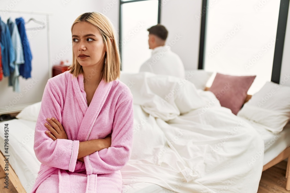 Fototapeta premium Young caucasian couple in conflict sitting on the bed at home.