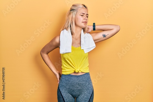 Beautiful blonde sports woman wearing workout outfit suffering of neck ache injury  touching neck with hand  muscular pain