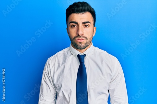 Young hispanic man wearing business clothes relaxed with serious expression on face. simple and natural looking at the camera.