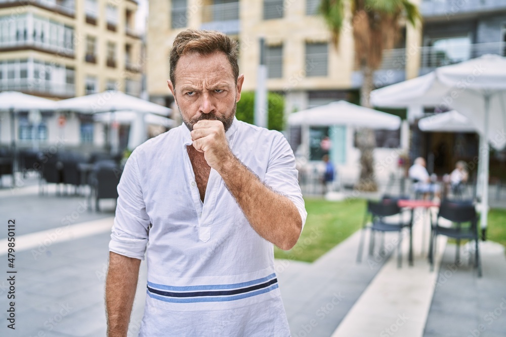 Middle age man outdoor at the city feeling unwell and coughing as symptom for cold or bronchitis. health care concept. Middle age man outdoor at the city feeling unwell and coughing as symptom for cold or bronchitis. health care concept.