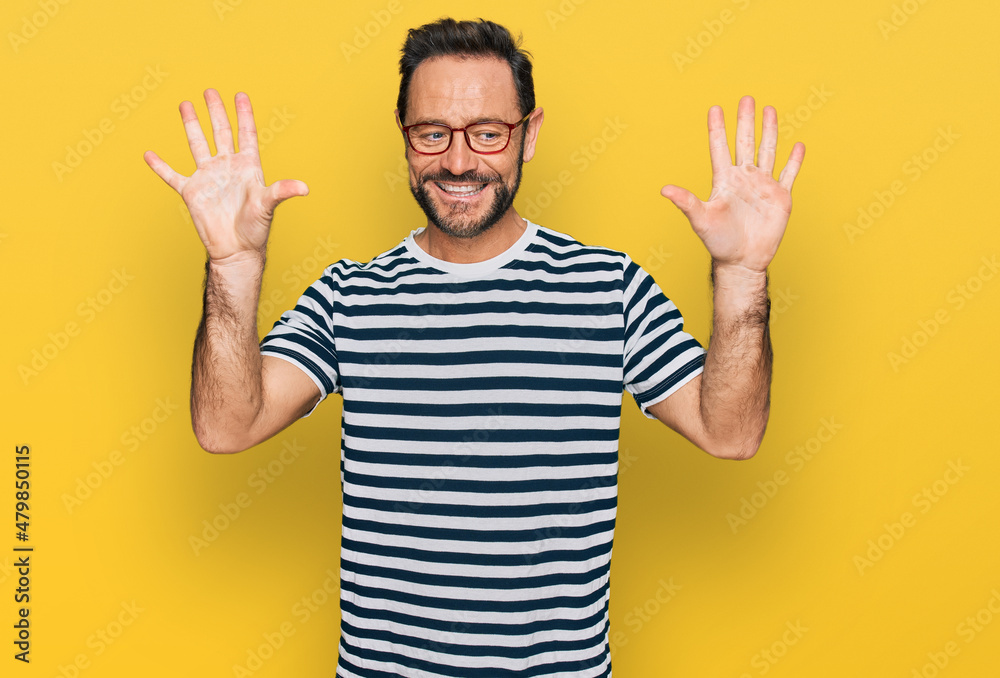 Middle age man wearing casual clothes and glasses showing and pointing up with fingers number ten while smiling confident and happy. Middle age man wearing casual clothes and glasses showing and pointing up with fingers number ten while smiling confident and happy.