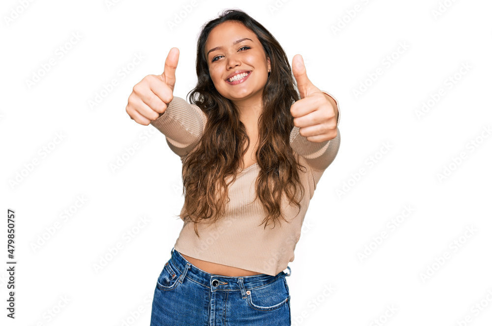 Young hispanic girl wearing casual clothes approving doing positive gesture with hand, thumbs up smiling and happy for success. winner gesture. Young hispanic girl wearing casual clothes approving doing positive gesture with hand, thumbs up smiling and happy for success. winner gesture.
