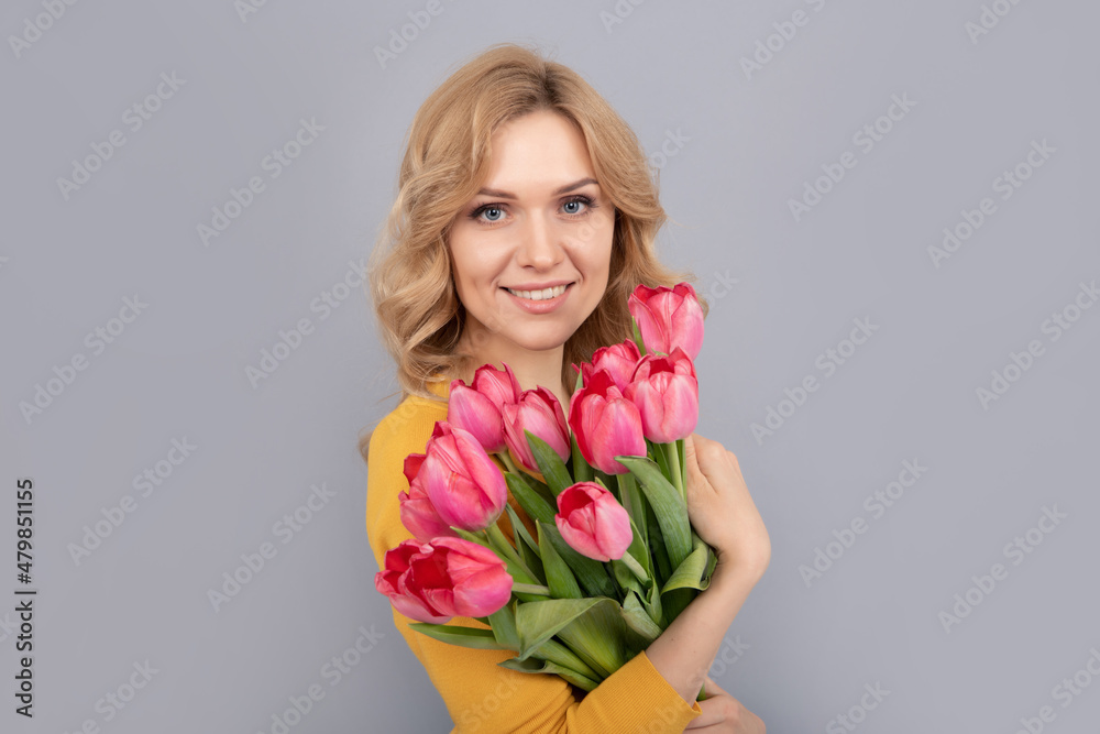 smiling woman with tulips. lady hold flowers for spring holiday. girl with bouquet