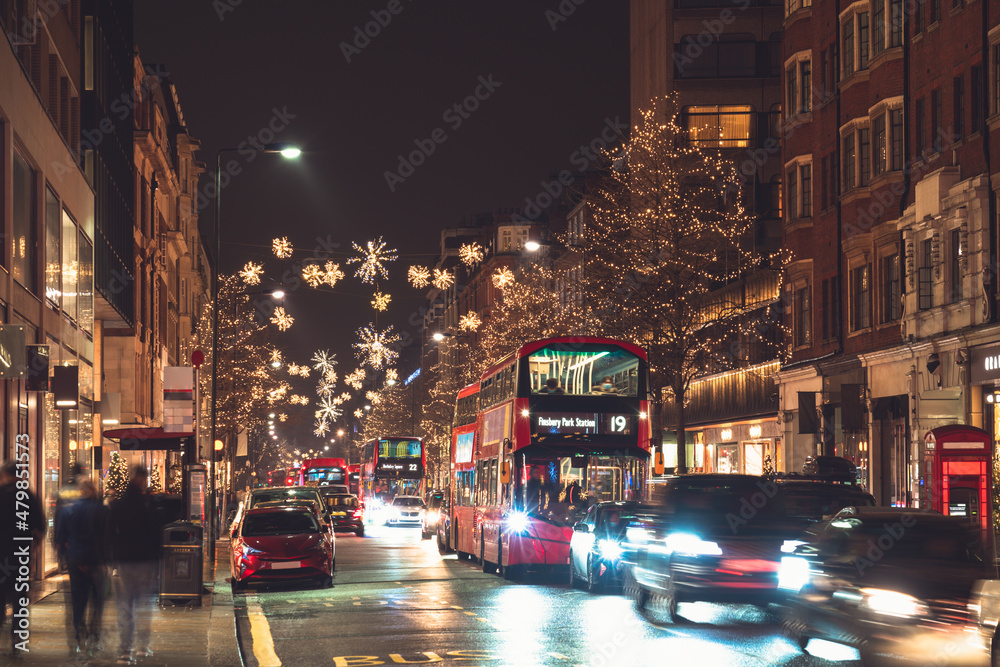 Red double decker bus on Knightsbridge street with Christmas lights  in London
