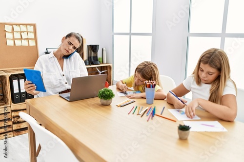 Mother and daughters working and drawing at office © Krakenimages.com