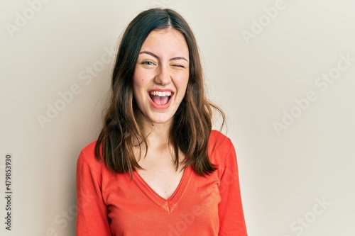 Young brunette woman wearing casual clothes winking looking at the camera with sexy expression, cheerful and happy face.