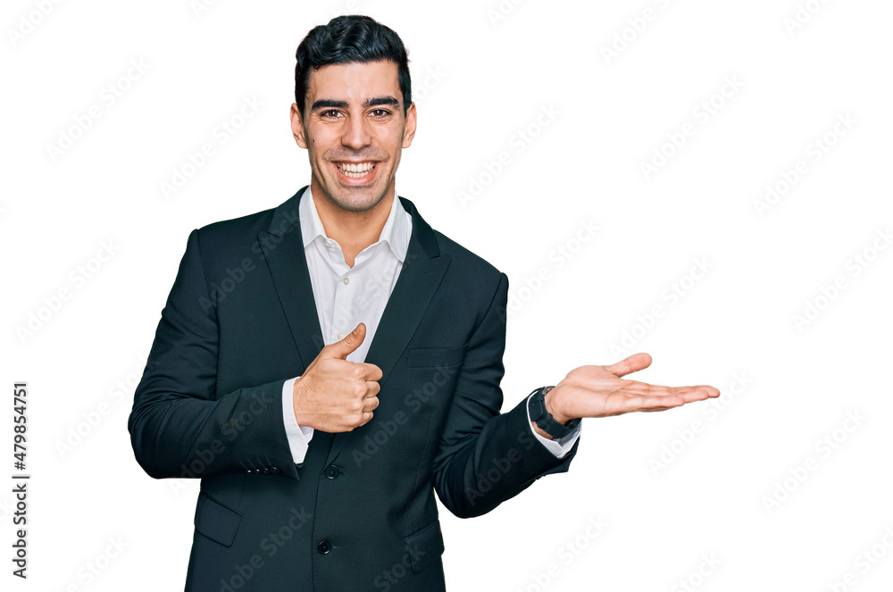 Handsome hispanic man wearing business clothes showing palm hand and doing ok gesture with thumbs up, smiling happy and cheerful Handsome hispanic man wearing business clothes showing palm hand and doing ok gesture with thumbs up, smiling happy and cheerful