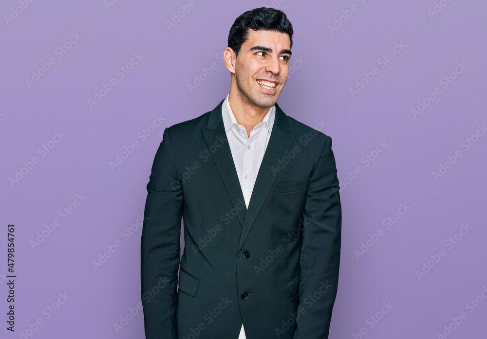 Fototapeta premium Handsome hispanic man wearing business clothes looking away to side with smile on face, natural expression. laughing confident.