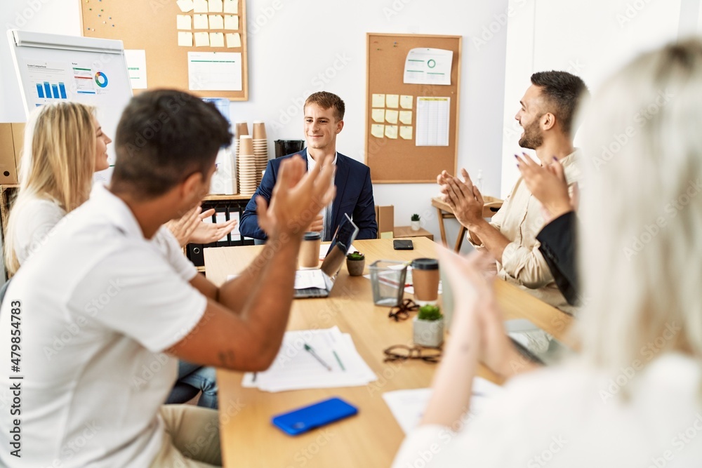 Obraz premium Group of young business workers smiling and clapping to partner at the office.