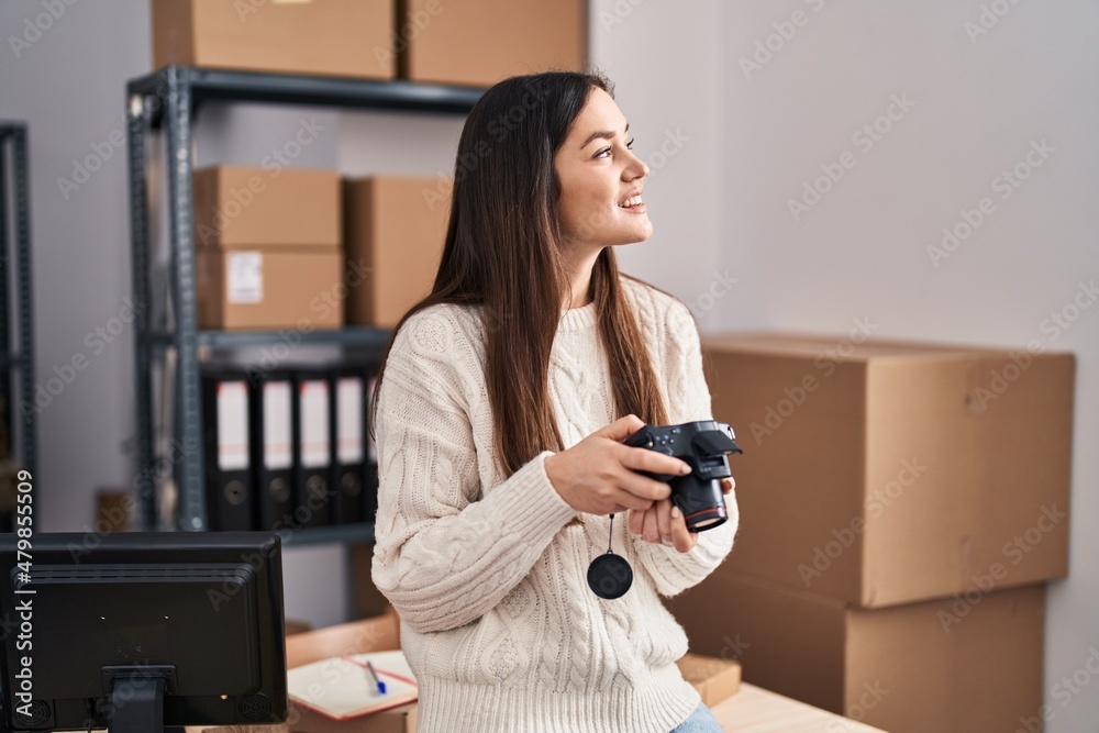 Young woman ecommerce business worker holding professional camera at office Young woman ecommerce business worker holding professional camera at office