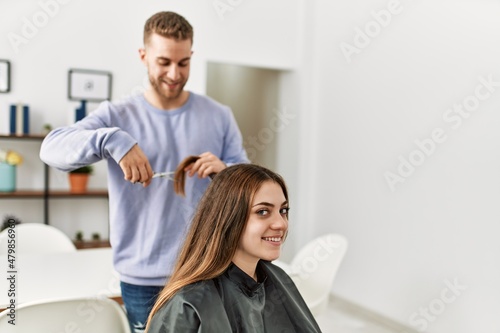 Young man cutting hair his girlfriend at home.