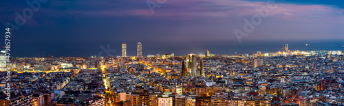 Aerial rooftop panorama of Barcelona at dusk. Spain