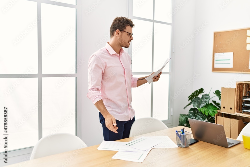 Young hispanic man working at office Young hispanic man working at office