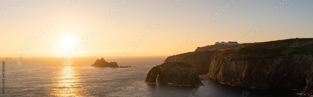 Land's End with Enys Dodman arch at sunset, Cornwall. United Kingdom