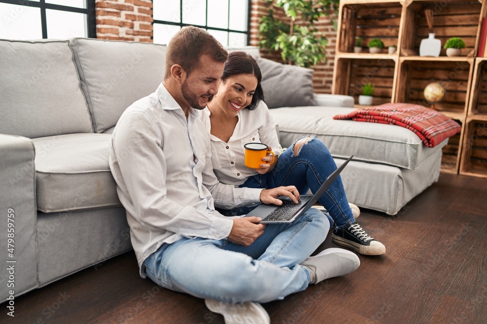 Man and woman couple using laptop and drinking coffee at home Man and woman couple using laptop and drinking coffee at home